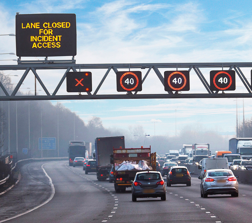 Overhead motorway gantry showing the message 'LANE CLOSED FOR INCIDENT ACCESS' with a red X above the left lane and red 40 mph limits above the other lanes